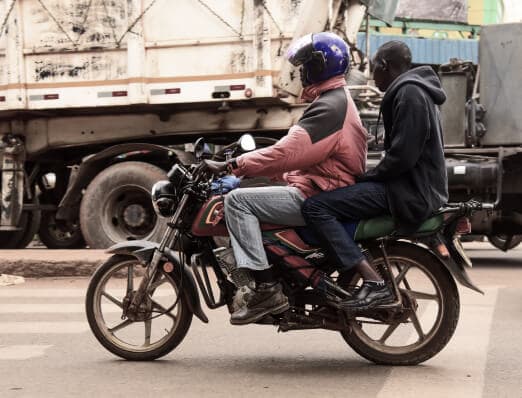 Boda riders carrying a passenger through Nairobi traffic